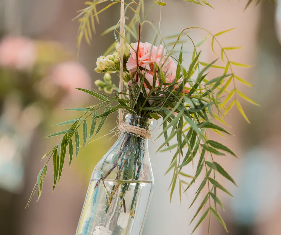 a bunch of flowers in a hanging vase diy dollar store wedding decor pieces. 