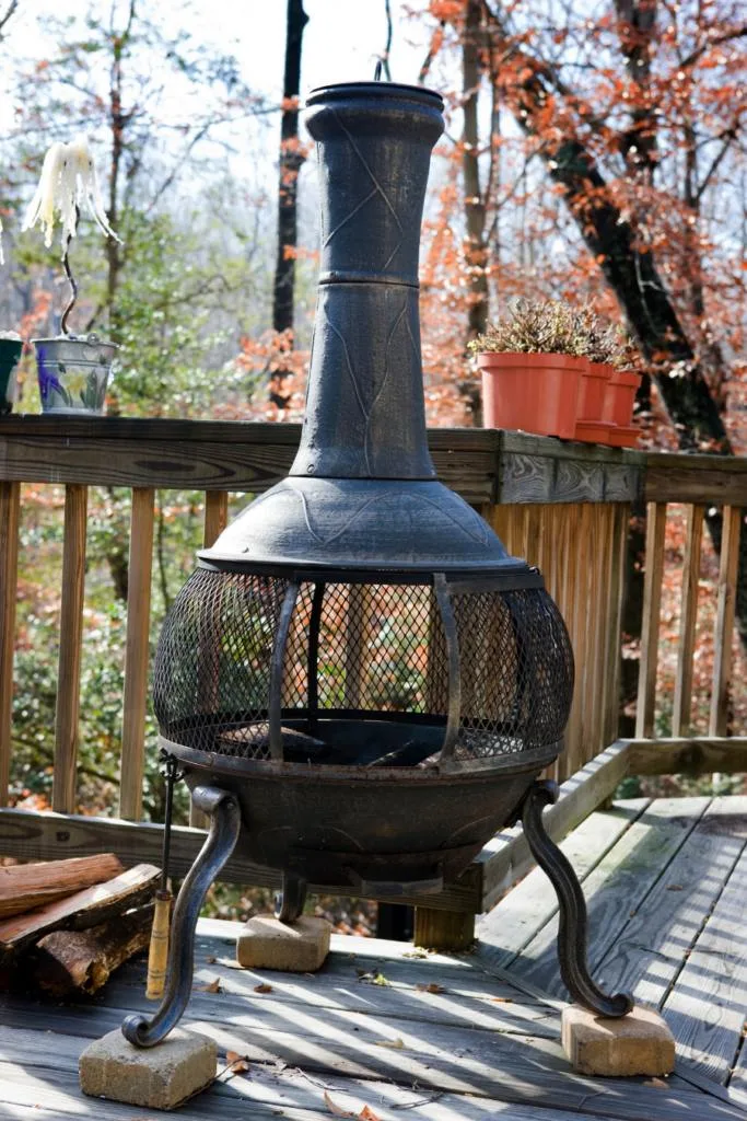 Chiminea not in use sitting on a deck during a fall day. 