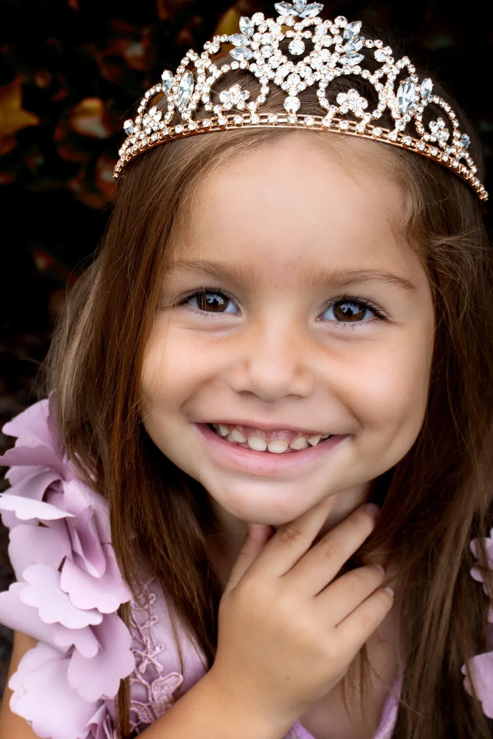 little girl smiling with a tiara and birthday princess gown