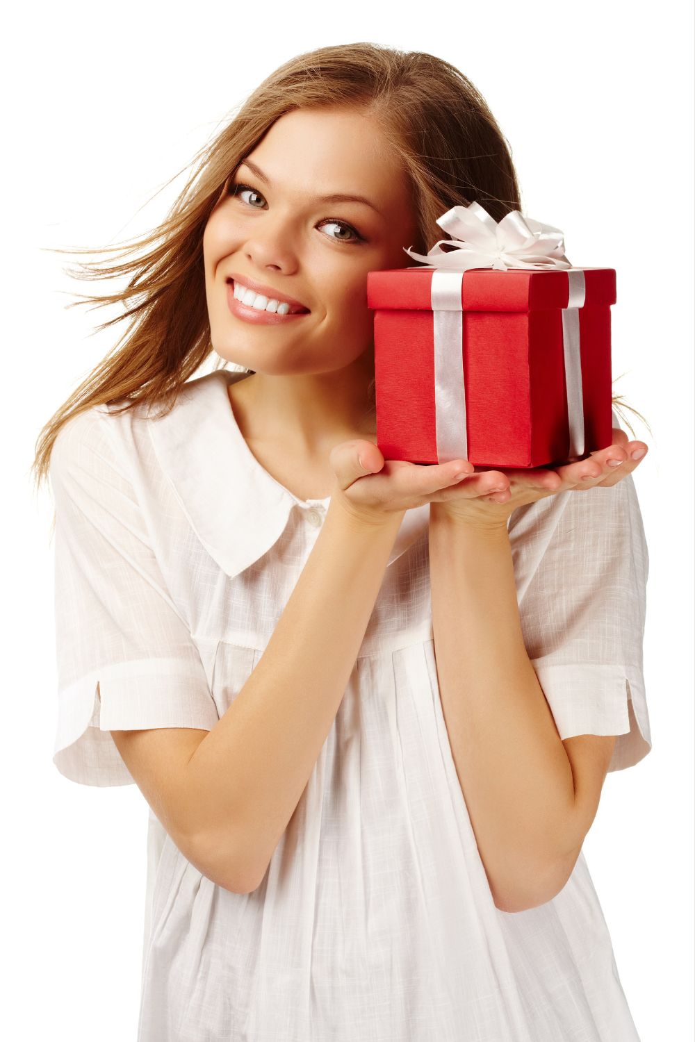 a girl in white holding a gift while smiling