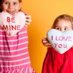 little girls holding up hearts that say be mine and I love you. Valentine Gifts for Little Girls
