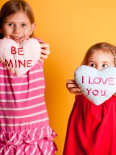 little girls holding up hearts that say be mine and I love you. Valentine Gifts for Little Girls